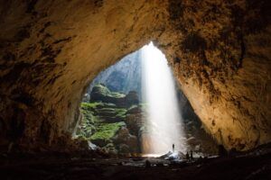 A light shining through a cave Description automatically generated
